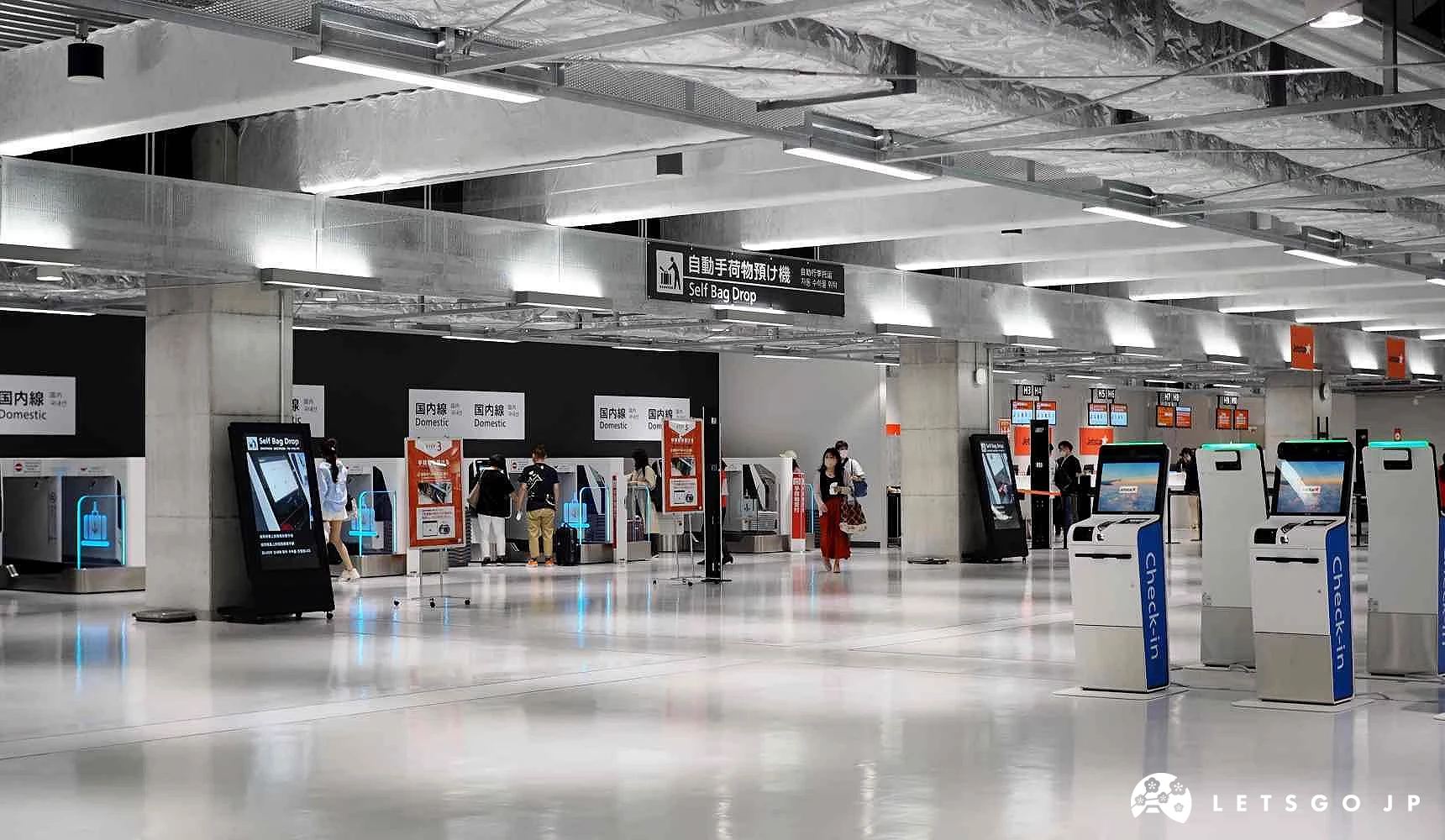 成田机场第三航厦2楼出发报到区,配置多台自助报到机与自动托运行李设备,旅客正在使用机台办理登机手续