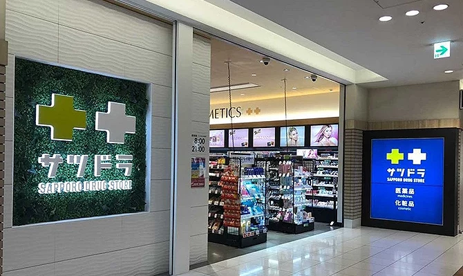 札幌车站 STELLAR PLACE B1 的札幌药妆(Satsudora)店面外观,明亮整洁的入口与绿色十字招牌醒目,店内贩售各式药品、美妆与日用品