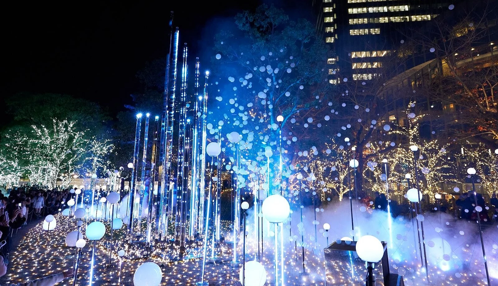 东京中城圣诞主灯区「Midtown Garden」夜景,蓝白色灯光随音乐闪烁,泡泡与雪花交织空中