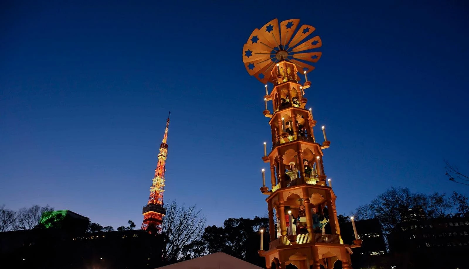 东京圣诞市集2025芝公园会场,黄昏夜色下的东京铁塔与约14公尺圣诞金字塔并立