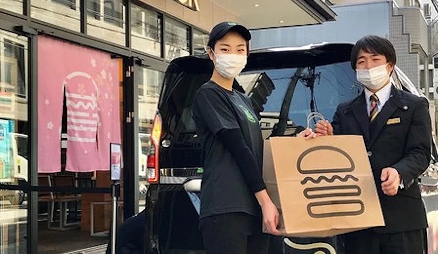 SHAKE SHACK员工在店门口前手拿外送提袋