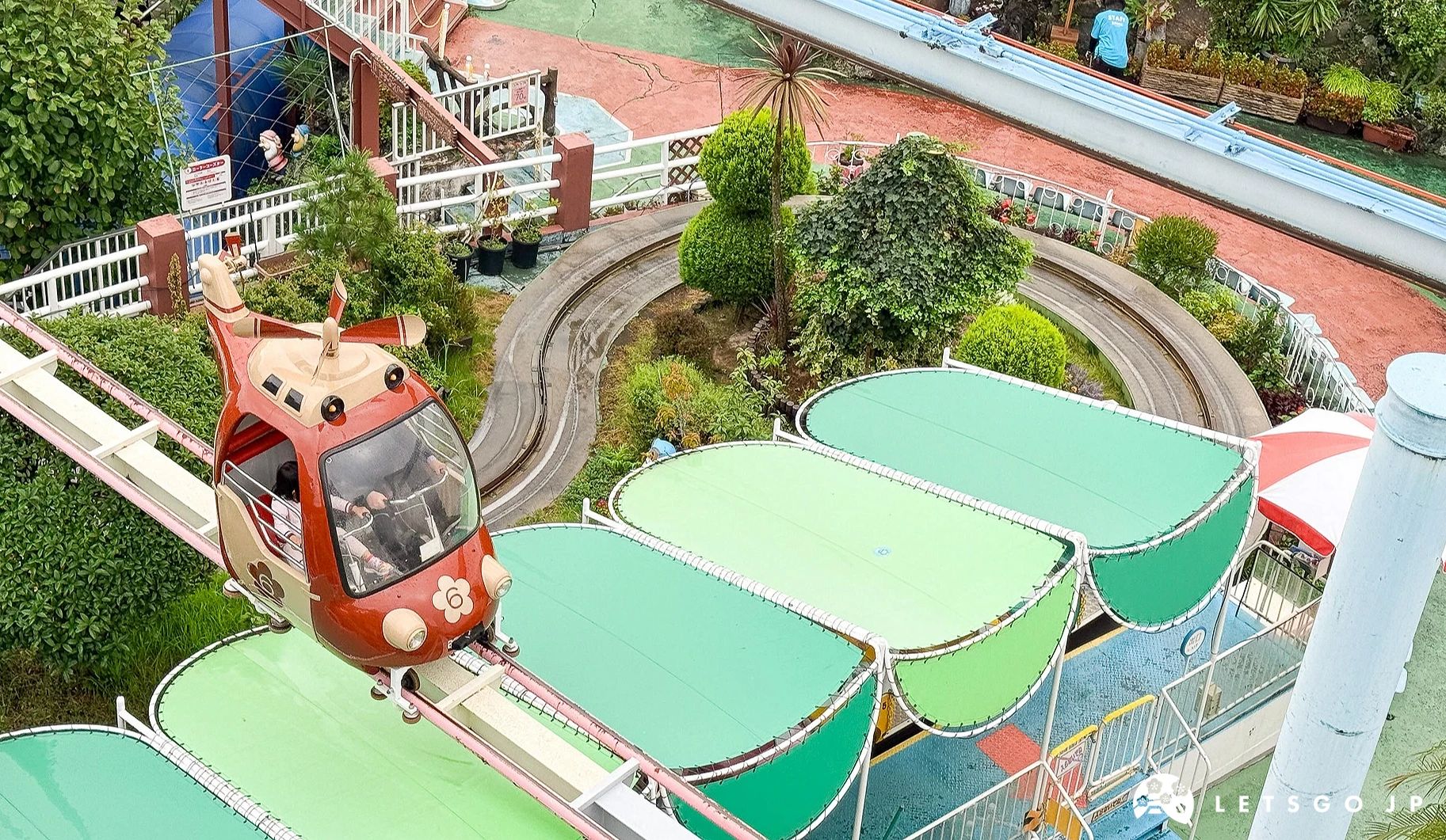 紅色直升機造型的遊樂設施在空中軌道上運行