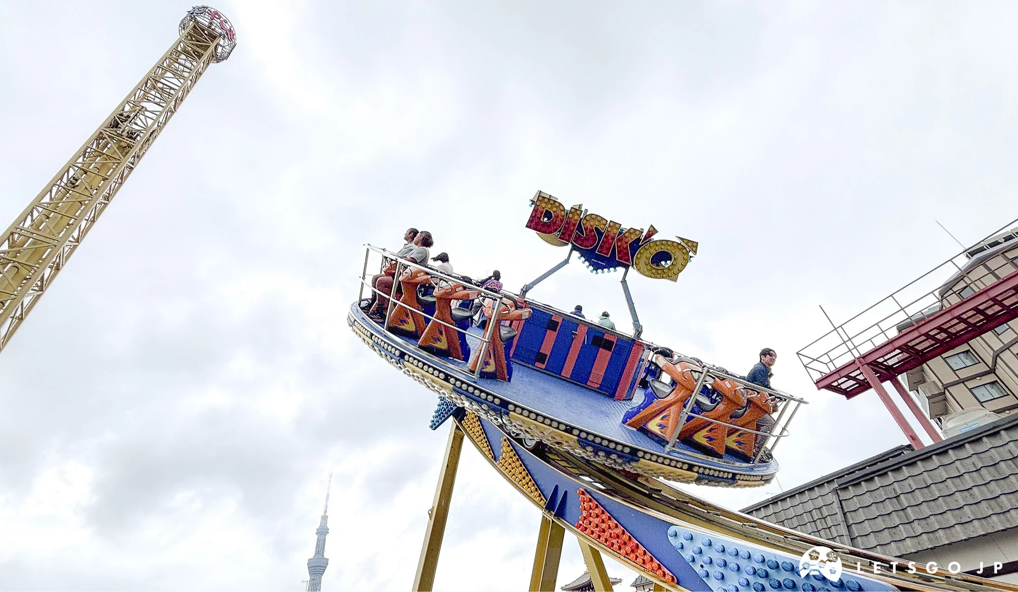 數人乘坐的圓盤設施,正沿著軌道擺盪至軌道的最高點