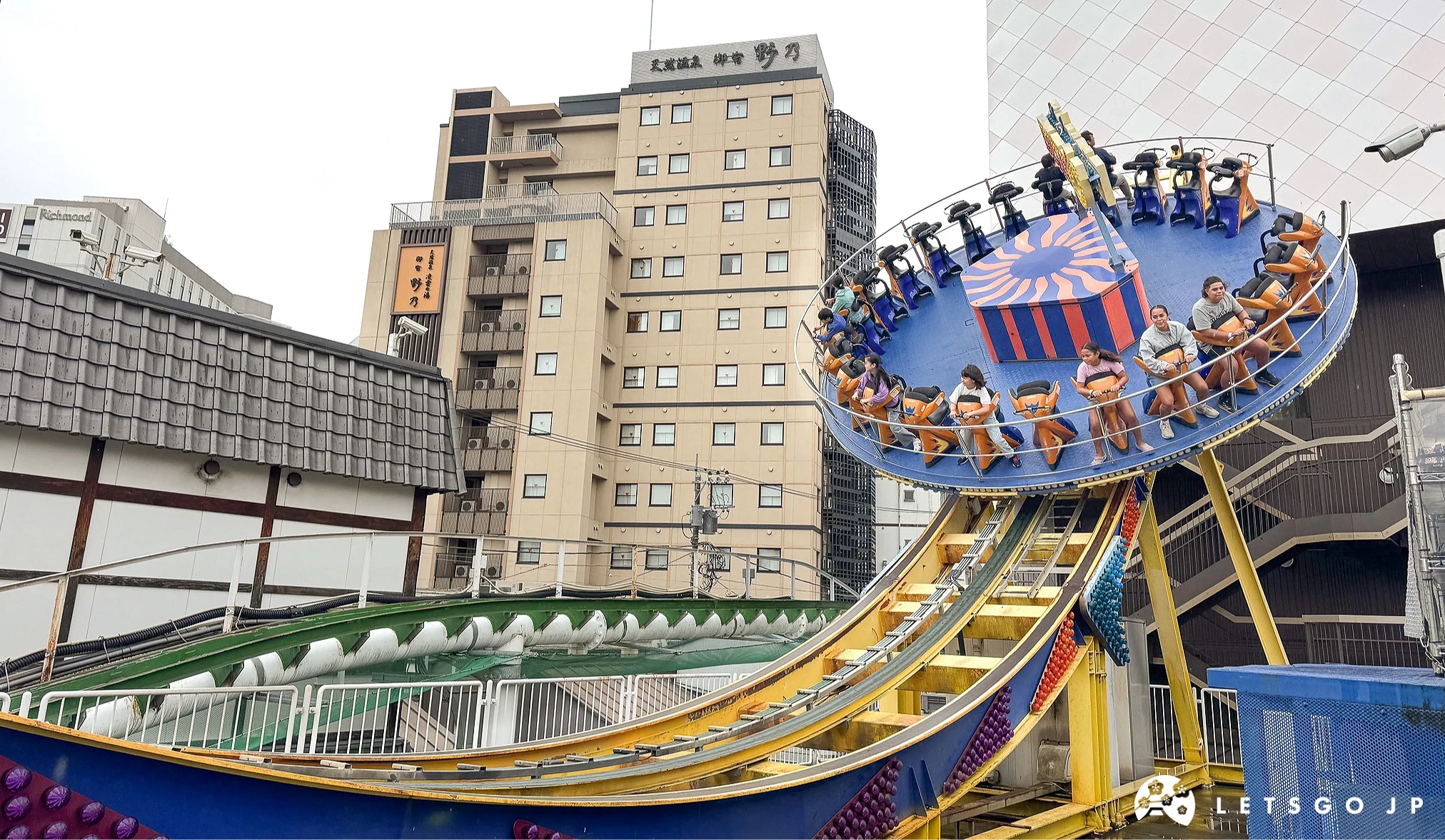 數人乘坐的圓盤設施,正沿著軌道擺盪至軌道的最高點