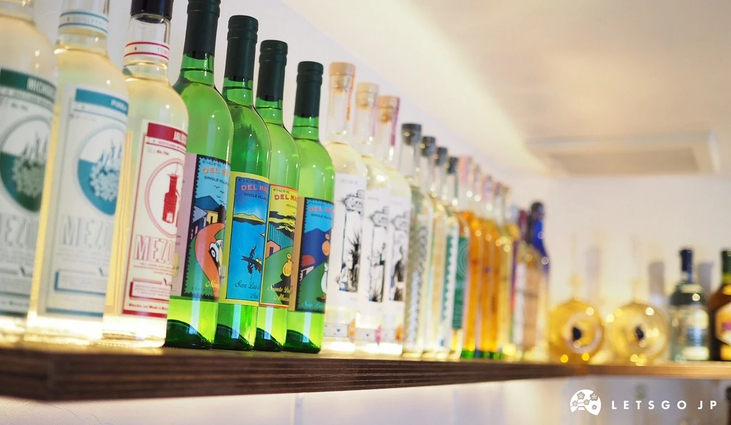 吧檯上方燈光照明下的多款龍舌蘭酒瓶。