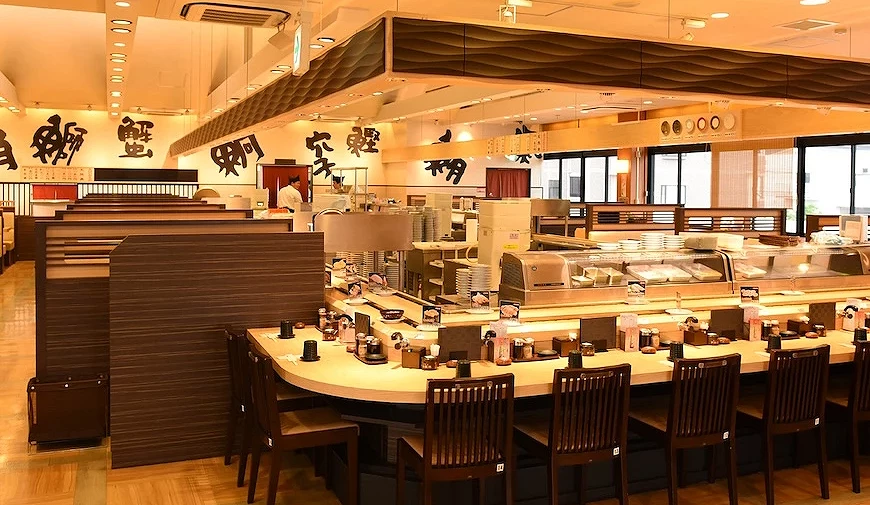 大起水産八尾店店内木质调及暖色调,墙壁上有各种鲜鱼汉字的书法装饰