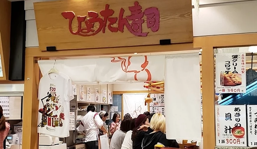 葫芦回转寿司店门口可以看到满坐的店内,门口上方是红色字体的LOGO配上木质调招牌