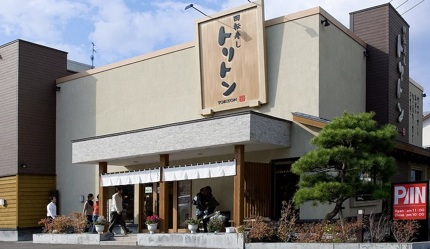 TORITON 回转寿司店铺,浅色调为主的独栋建筑,木质的招牌写这黑色书法字体的logo