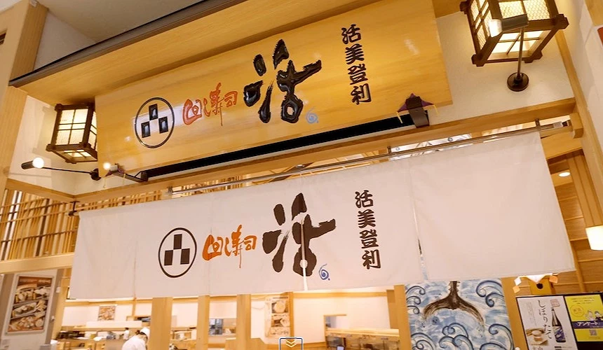 活美登利店门口,浅色木头墙及白色布帘,logo是大大的「活」书法字