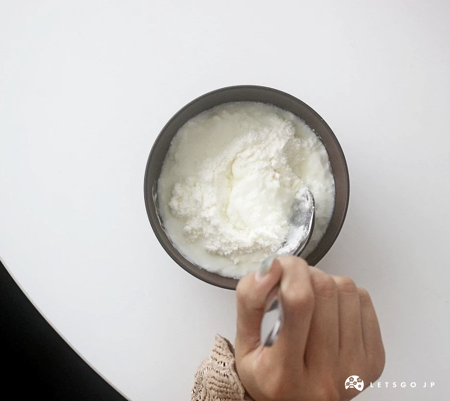 手持湯匙在優格碗中緩慢攪拌。