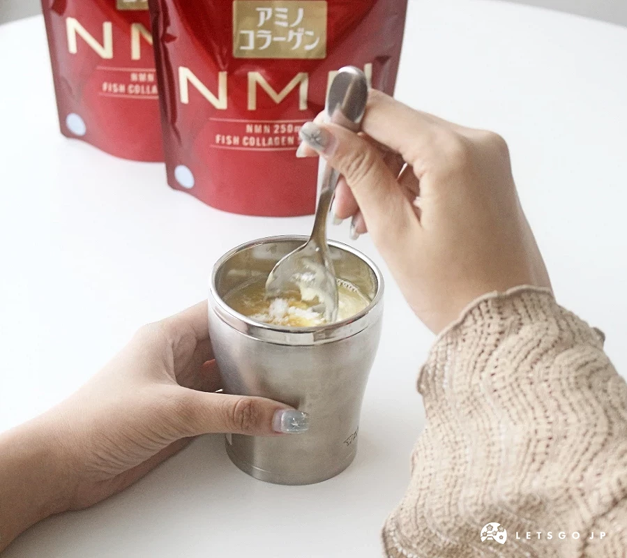 手持湯匙在銀色容器中攪拌已加入粉末的柳橙汁。