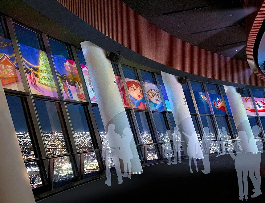 展望台上的玻璃窗倒映著都市的夜景與聖誕節的影像