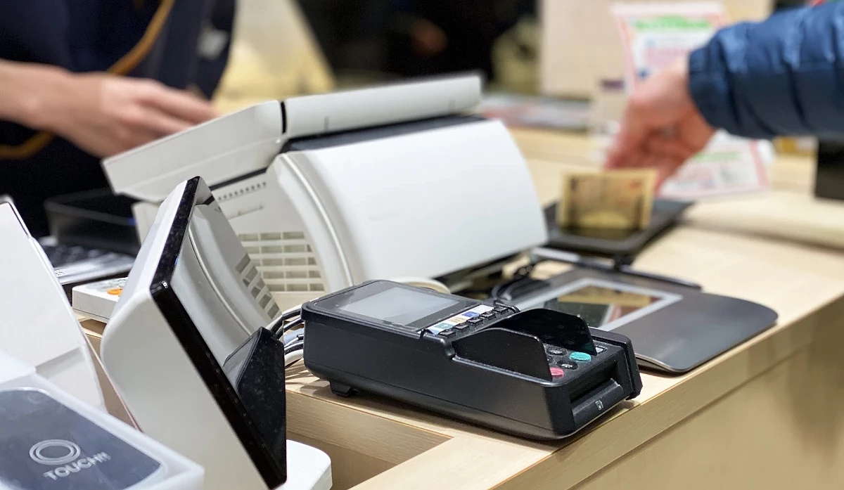 酒屋的結帳櫃檯,顧客正在使用信用卡機進行付費。