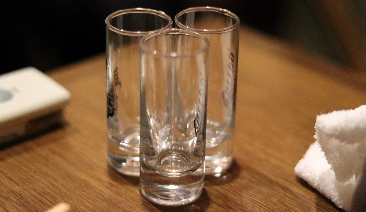 三個高腳、清澈的空啤酒杯並排放在桌面上,等待倒酒。