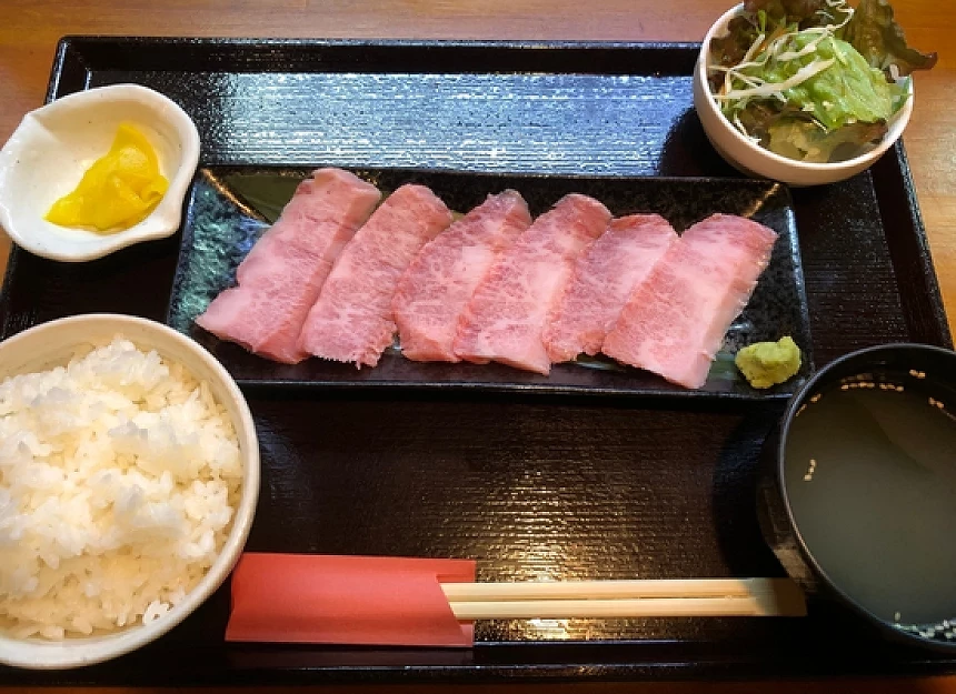 白飯與生菜與湯品與肉片的定食放在盤子上