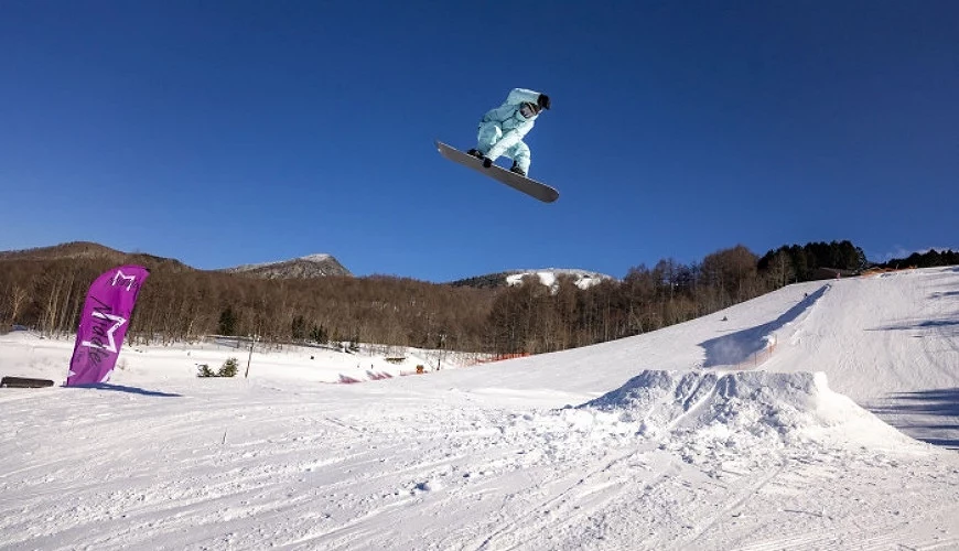 在雪地上以滑雪板躍起的滑雪客
