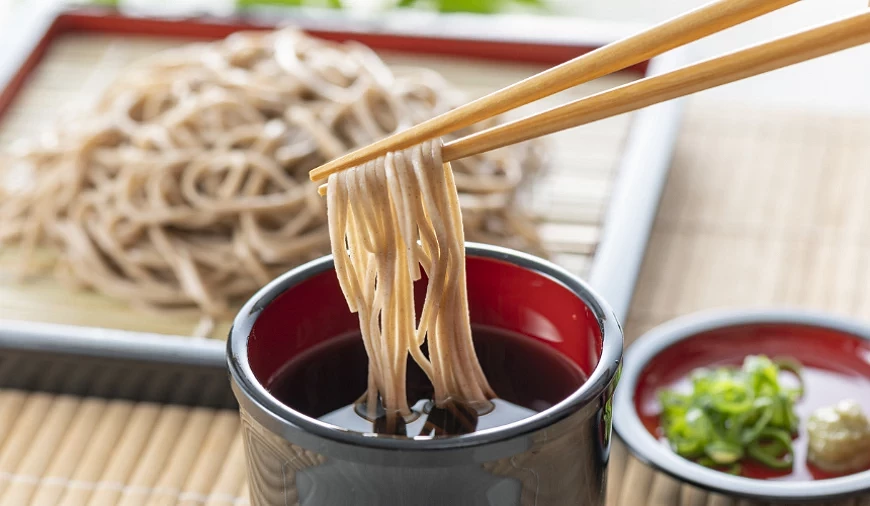 以筷子夾取蕎麥麵沾醬汁