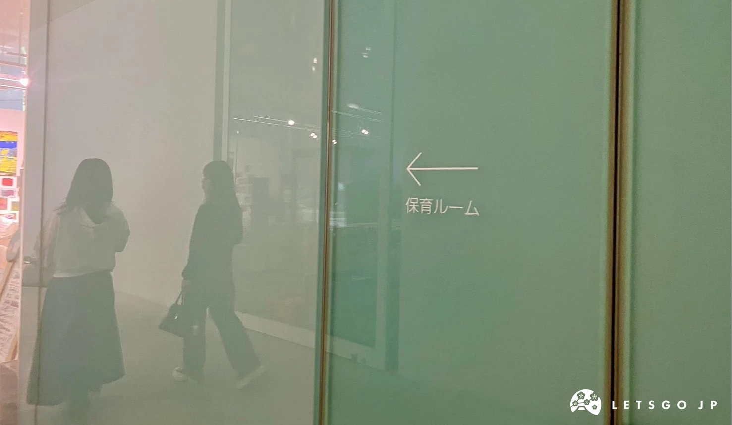 美術館內部走廊,一扇玻璃門上寫著保育ルーム