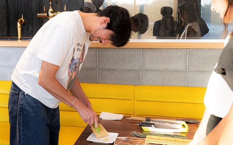 男子在木桌上用磨板磨山葵