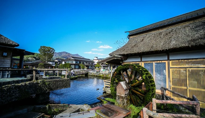忍野八海的池塘與周邊日式建築,水面映出天空與遠山的倒影