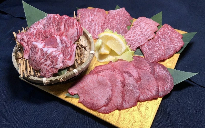 牛舌燒肉拼盤，旁有檸檬片裝飾