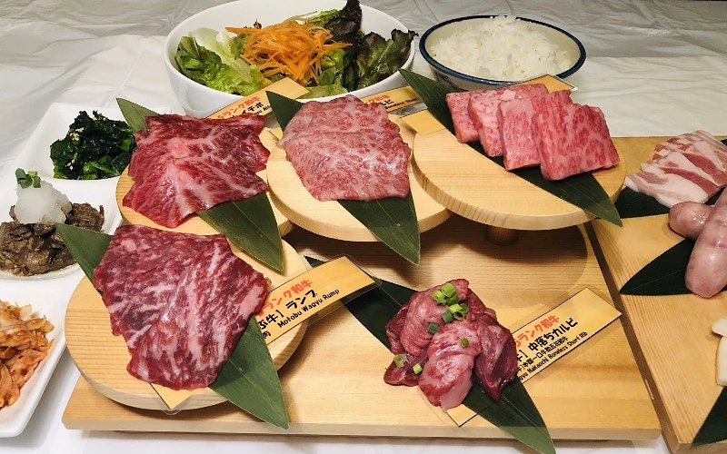 不同部位石垣牛牛肉與配菜擺放於多層木盤上，附生菜與白飯