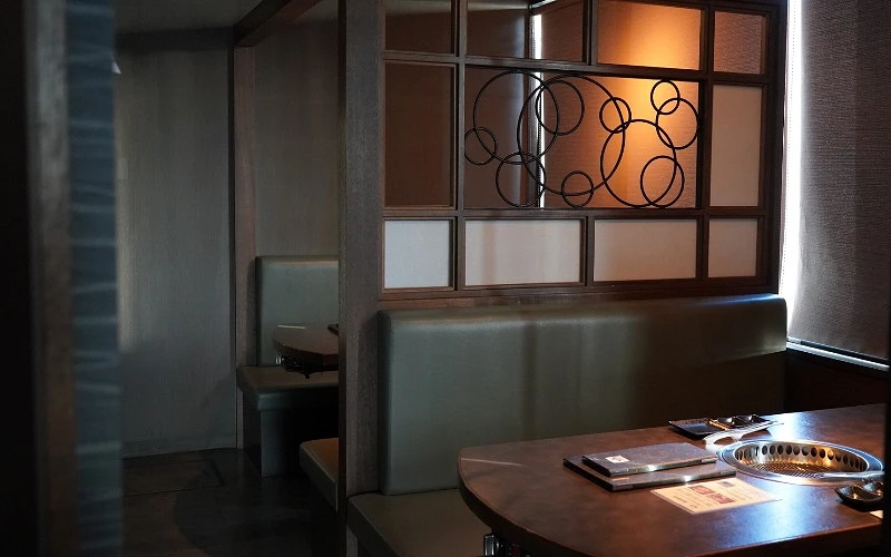 半包廂燒肉座位區，桌上設有內建烤爐與餐具
