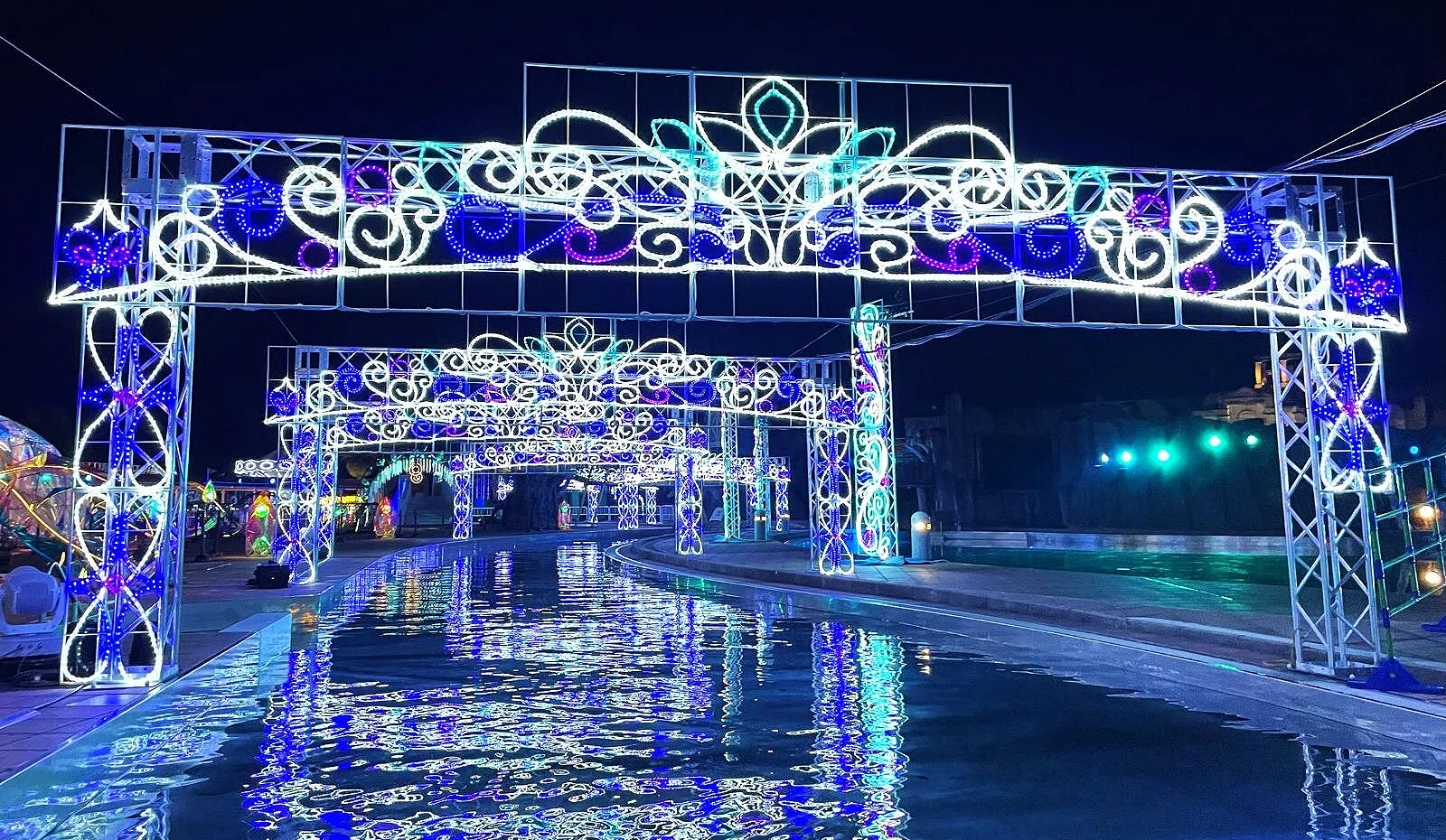 拉格娜登堡园内的水上灯光拱门以蓝白光线照亮水面,形成倒影与流动光影