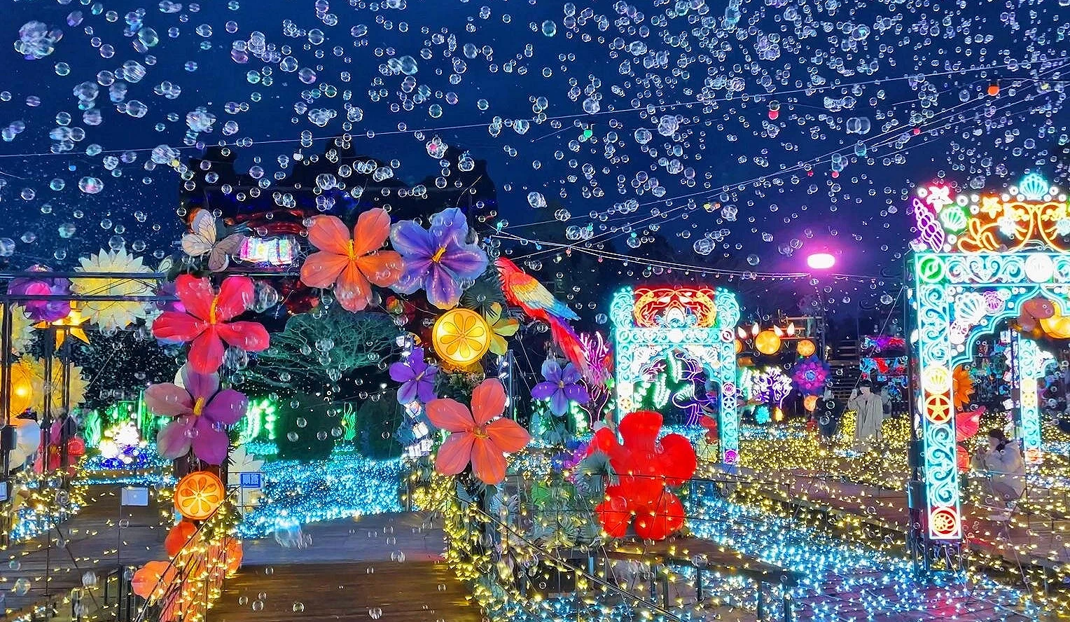 伊豆 Granpal 公园的灯饰活动现场,缤纷灯光与花卉装饰点缀夜色,空中飘满泡泡,营造出浪漫奇幻的节庆氛围