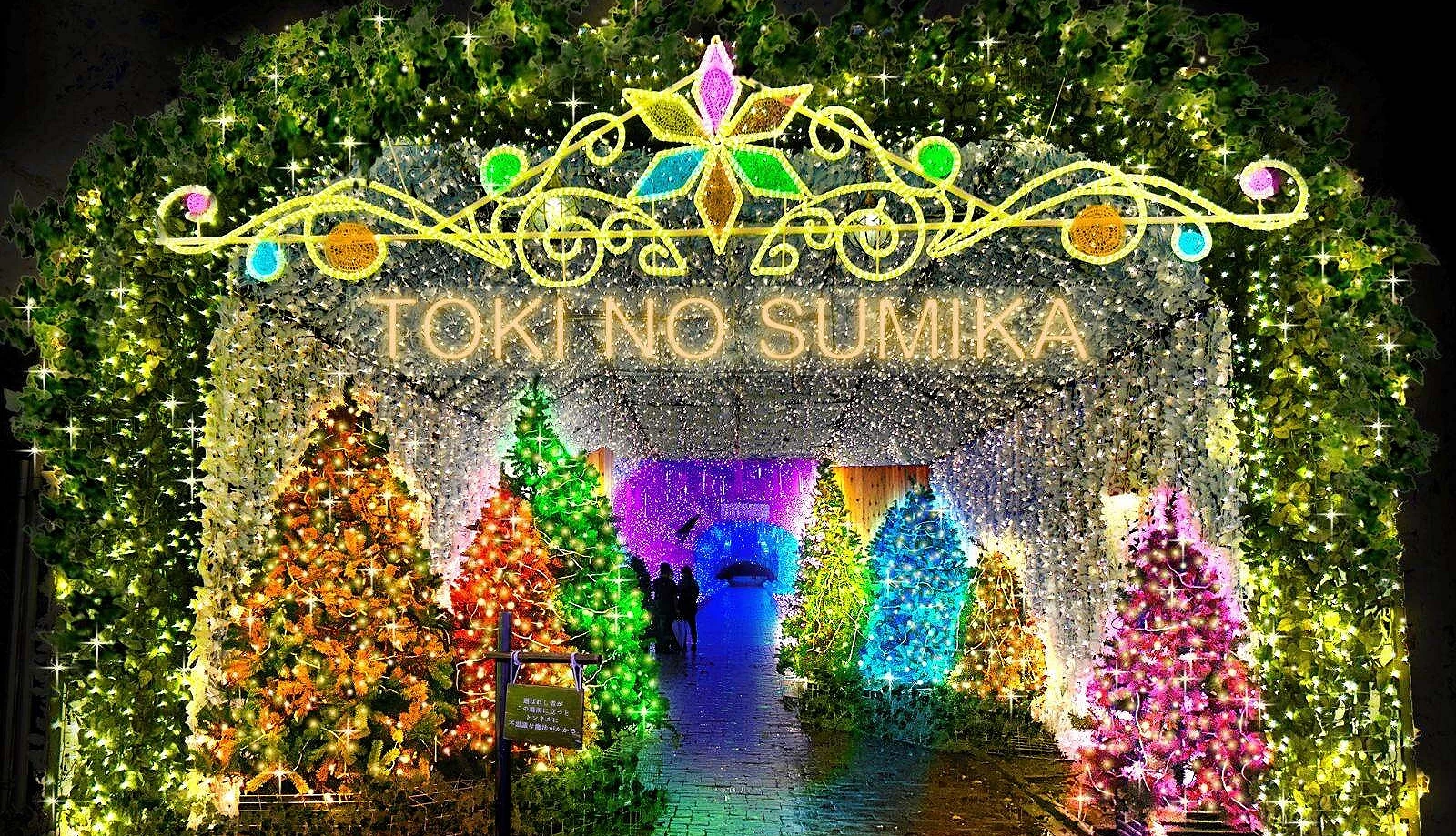 静冈时之栖园区入口处的灯饰拱门与彩色圣诞树装饰,闪耀金光与彩灯