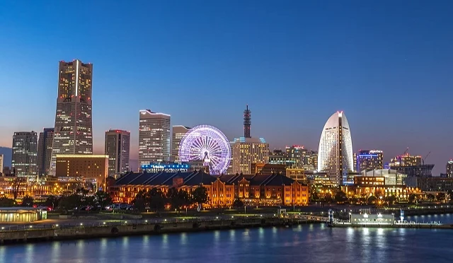 横滨港湾夜景,包含摩天轮、红砖仓库与高楼群灯光倒映在水面上,呈现跨年期间港都的迷人风景