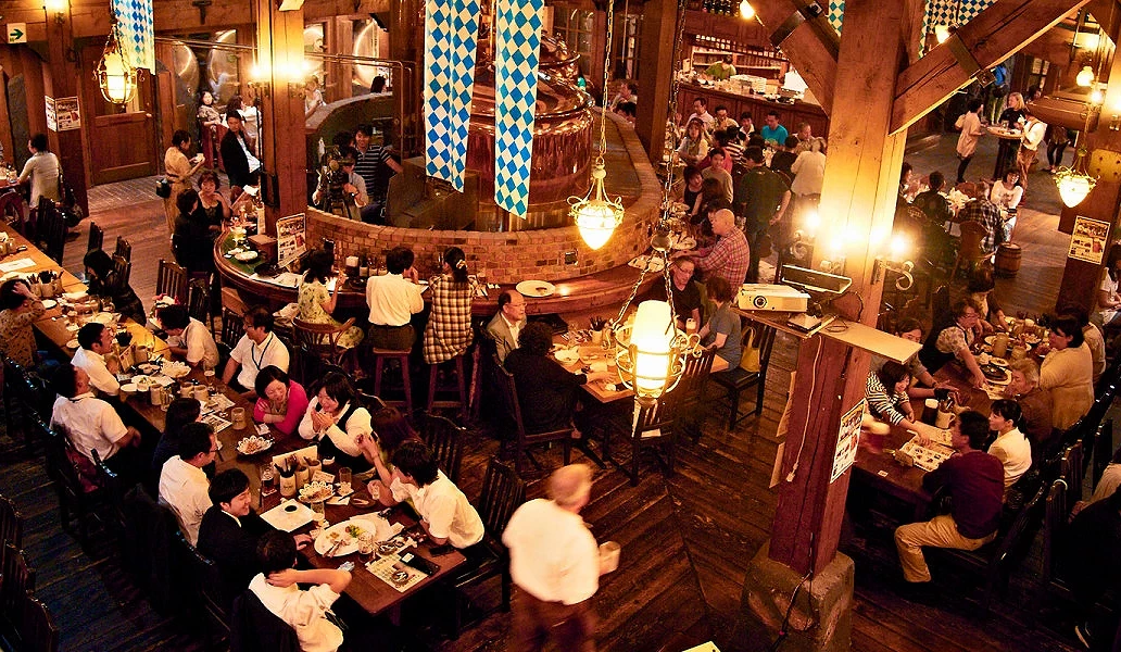 小樽仓库 No.1 的啤酒馆内部,旅客在木质装潢与酿造设备环绕的空间里用餐