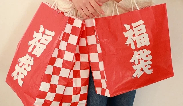 手提多个红白相间的福袋