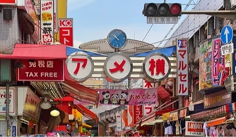 上野阿美横丁商店街入口挂着大型「アメ横」招牌,街道旁林立各式店铺与看板