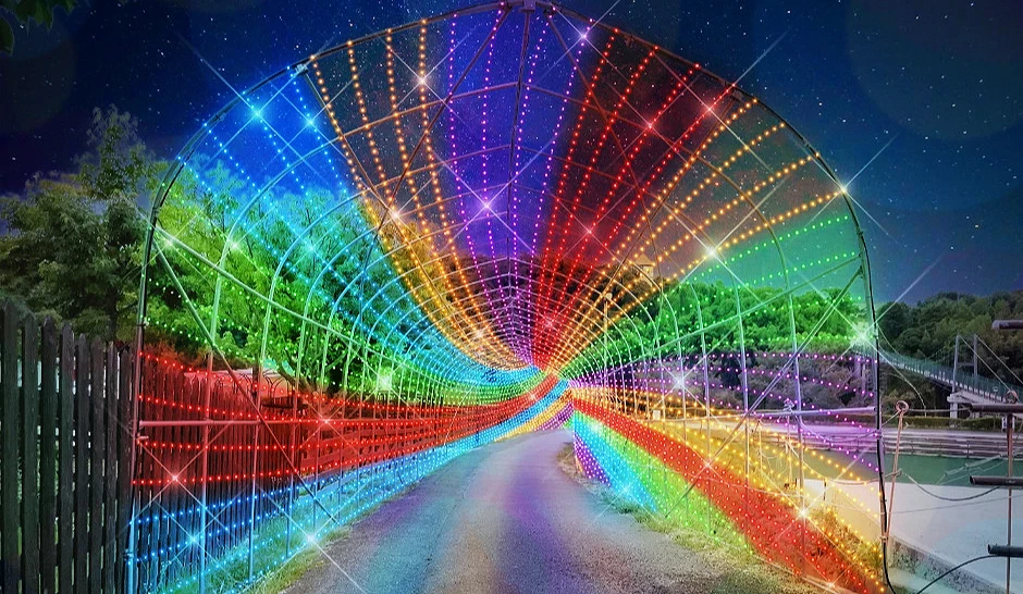 彩虹灯光构成的隧道蜿蜒向前,色彩流动如旋涡,吸引游客驻足拍照