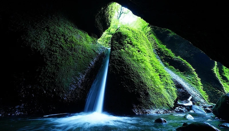 岩壁上充满绿色青苔的洞穴瀑布