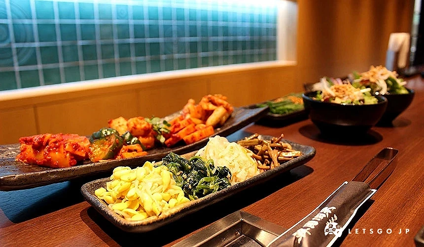 有泡菜醃蘿蔔等組合的小菜放在盤子上