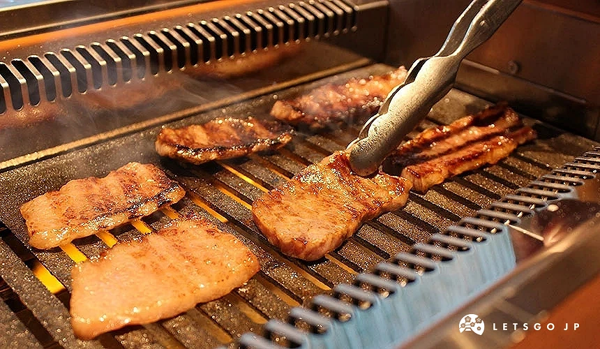 用夾子夾住燒肉網上的其中一片燒肉