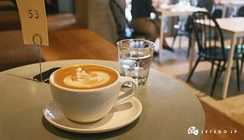 咖啡廳桌上擺放拿鐵、冷水杯