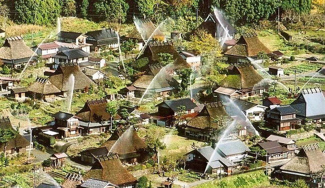 夏天在屋顶洒水的茅葺屋