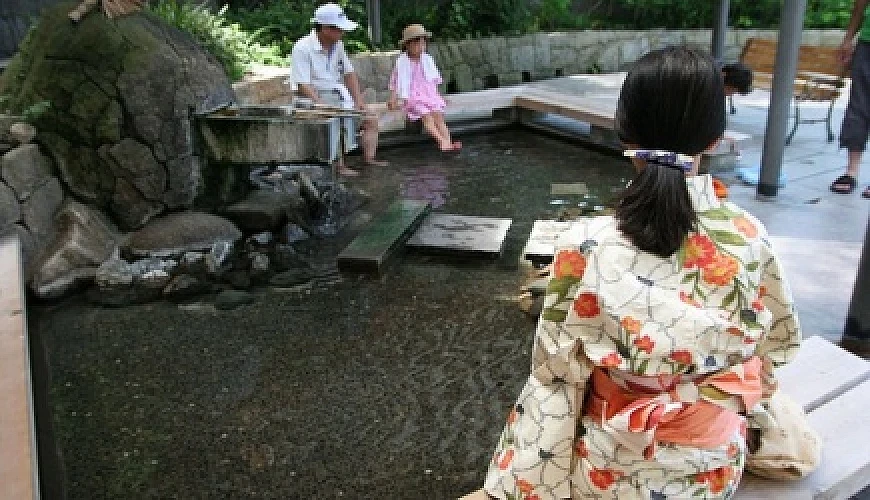 在溫泉街上泡足湯的遊客