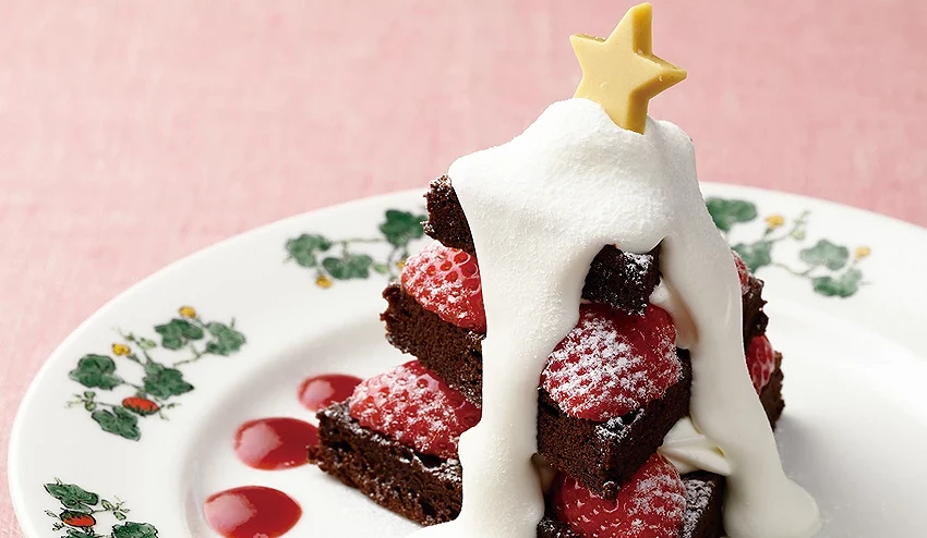 六花亭吃茶室冬季限定甜点,以三层巧克力蛋糕与新鲜草莓堆叠成圣诞树造型,覆上滑顺鲜奶油并以白巧克力星星点缀,盘面以莓果酱营造节庆感