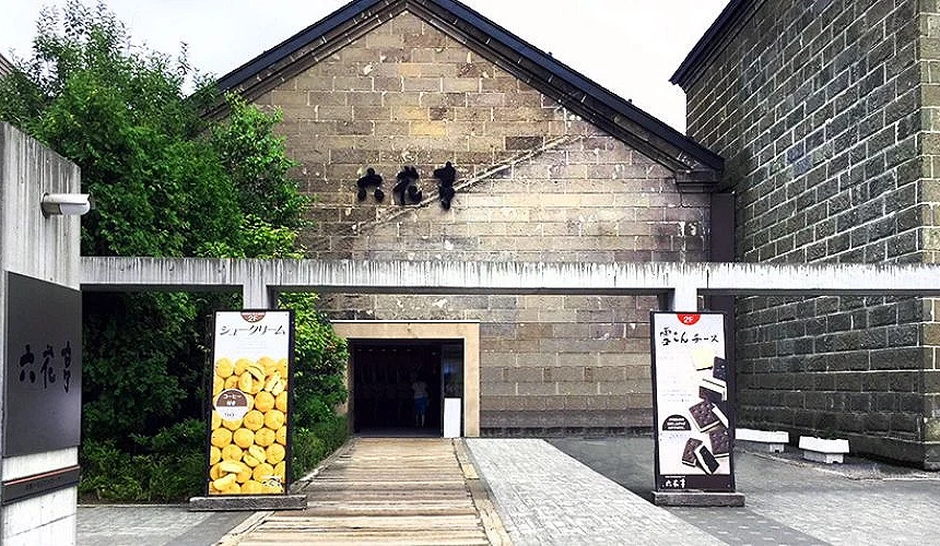 六花亭小樽运河店的石造外观入口,左右放置霜淇淋与点心海报