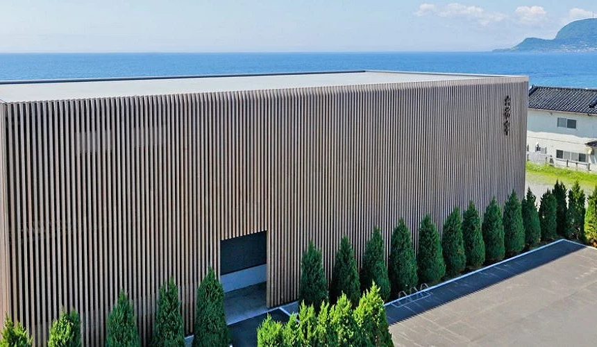 六花亭函馆渔火通店的木质直条外墙建筑,坐落在海边,后方一望无际的蓝色海景非常醒目