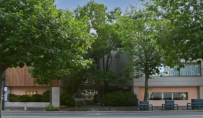 六花亭带广本店的建筑外观,被树木环绕,门口可见鹿雕像与简洁的招牌