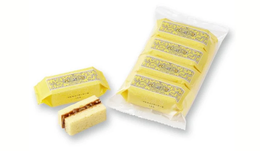 奶油夹心蛋糕的包装与实物示意,袋中整齐排放多个黄色包装的蛋糕,前方展示的蛋糕,可见夹层中焦糖奶油与核桃,呈现松软蛋糕搭配浓郁内馅的样貌