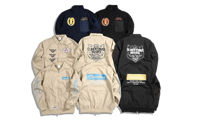 多件立領外套與夾克平鋪排列,背面與袖口印有 OLDEN TIMES 標語與圖樣