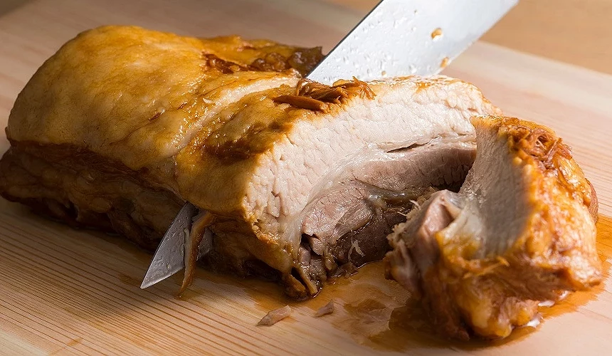 正在分切一整块叉烧肉的模样