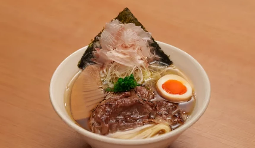 一碗有笋、葱花、溏心蛋、柴鱼片等配料的拉面