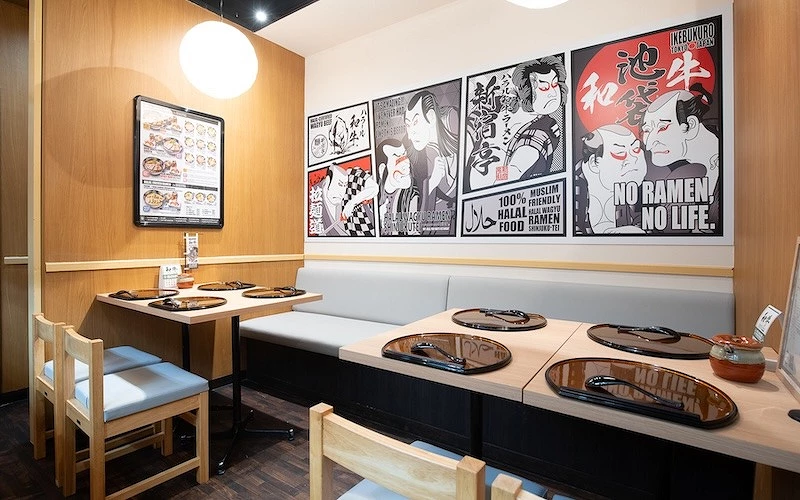 餐廳室內座位區，牆面浮世繪風格海報與整齊擺放的餐具